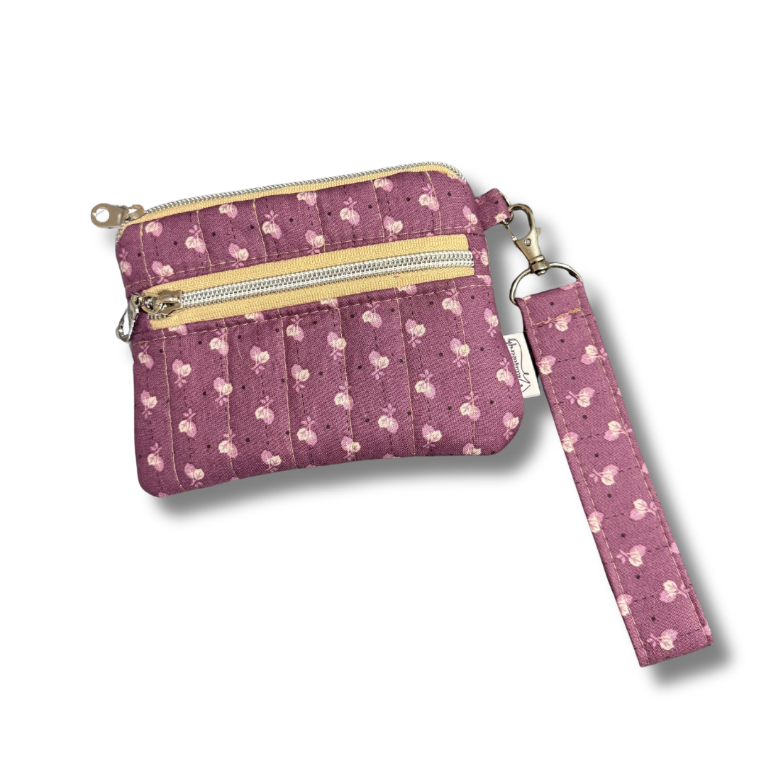 Purple patterned wallet with a matching wristlet on a white background