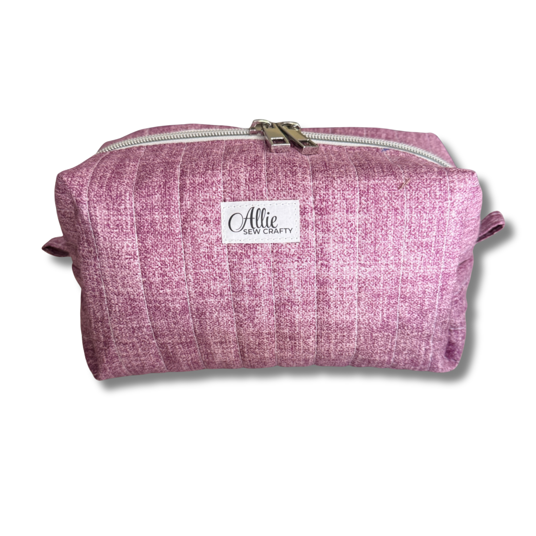 A mauve quilted fabric cosmetic pouch with a white brand label reading 'Allie Sew Crafty' on a white background.