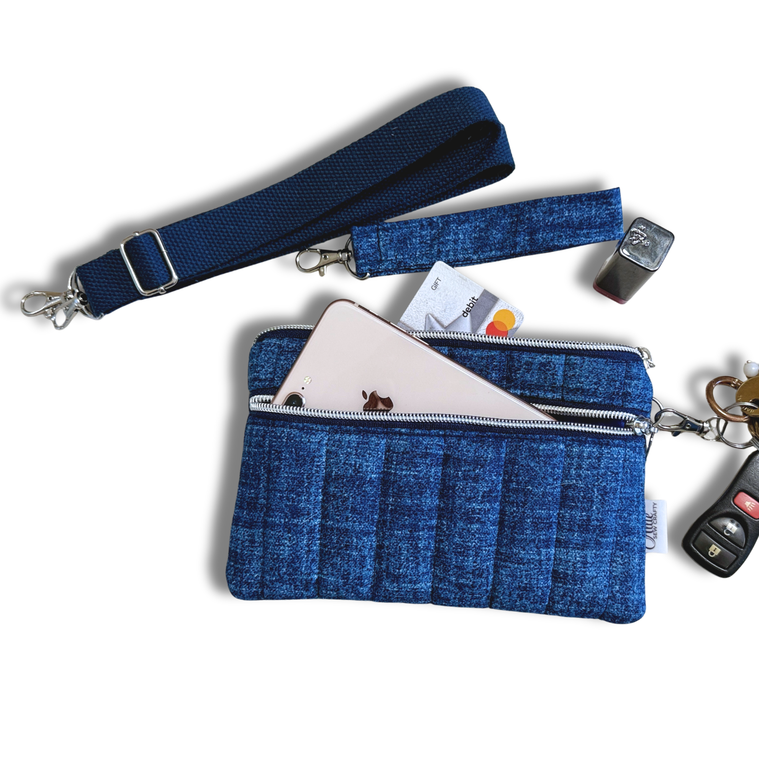 A blue woven wallet with a wrist strap, shown open with a phone, cards, and keys inside on a white background.