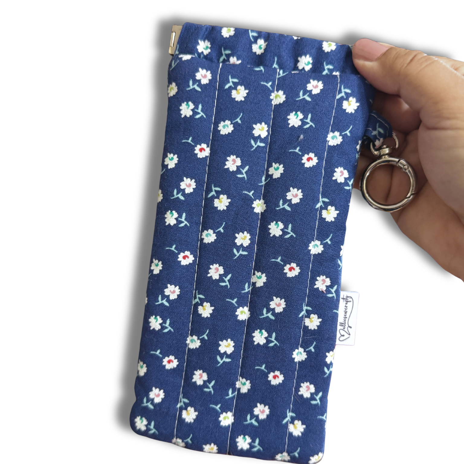 Blue White Daisies quilted Flexi Frame Pouch clipped to a black tote bag handle, holding sunglasses
