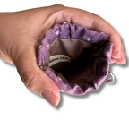 hand opening a snap on pouch showing the tan lining and tag that says Psalms 34:5