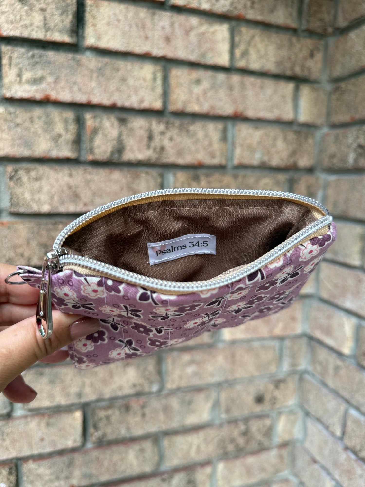 open zipper pouch with hand holding it in a brick wall background and the label Psalms 34:5