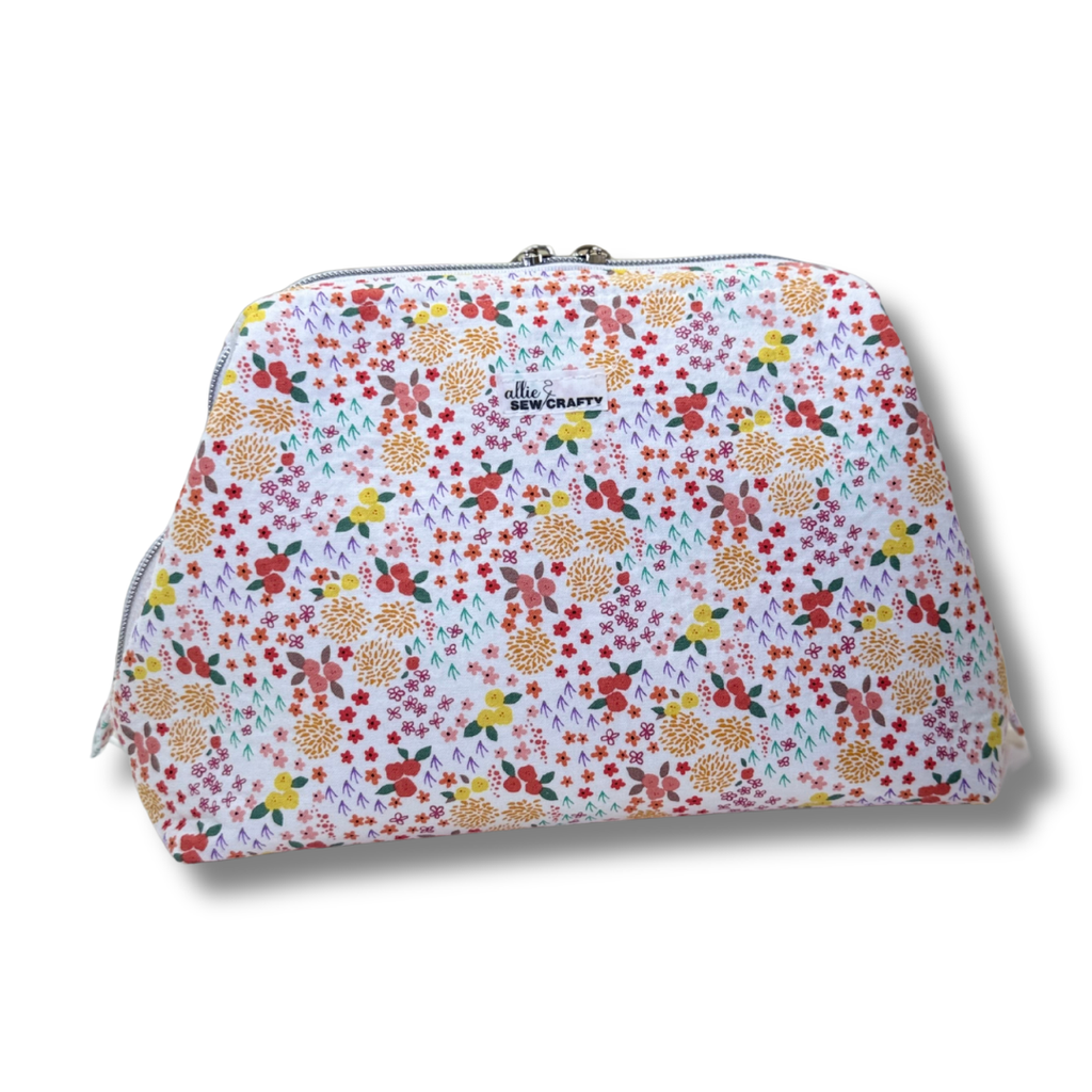 Floral patterned pouch with 'The Sew Crafty' label on a white background