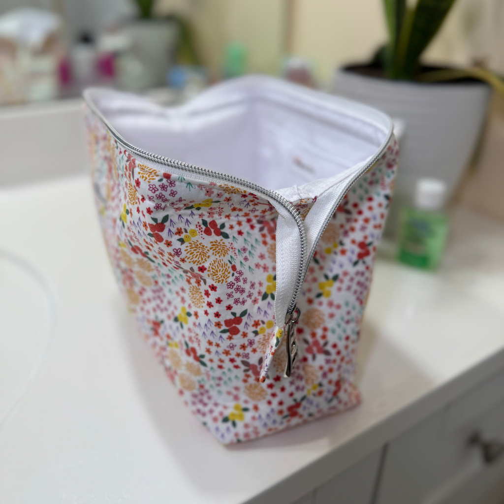Floral-patterned pouch with a zipper on a white surface