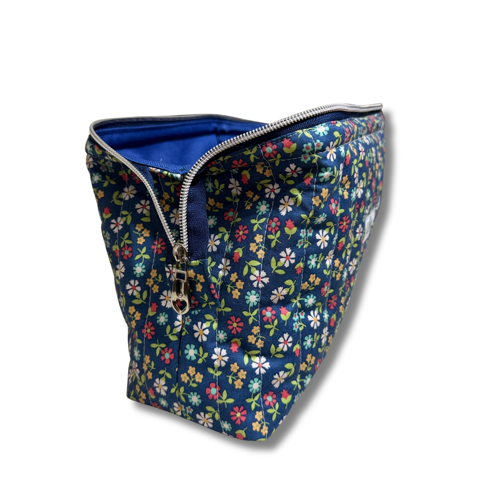 Side of full view pouch open with navy blue zipper and silver hardware, quilted pouch navy fabric with wildflower print