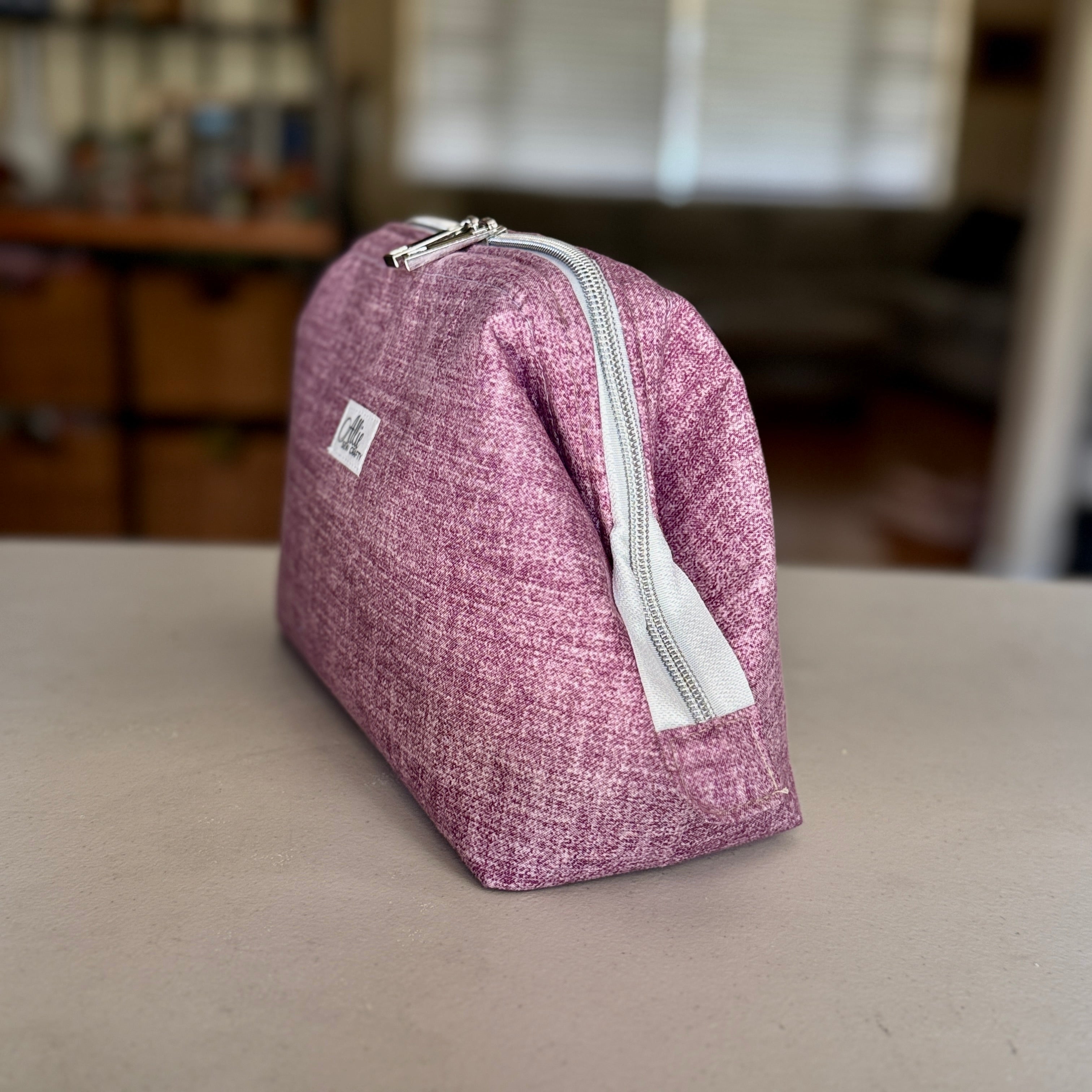Closed Solid Heathered Plum smooth quilted Full View Pouch, front view, with silver double zipper and Allie Sew Crafty label on a white background