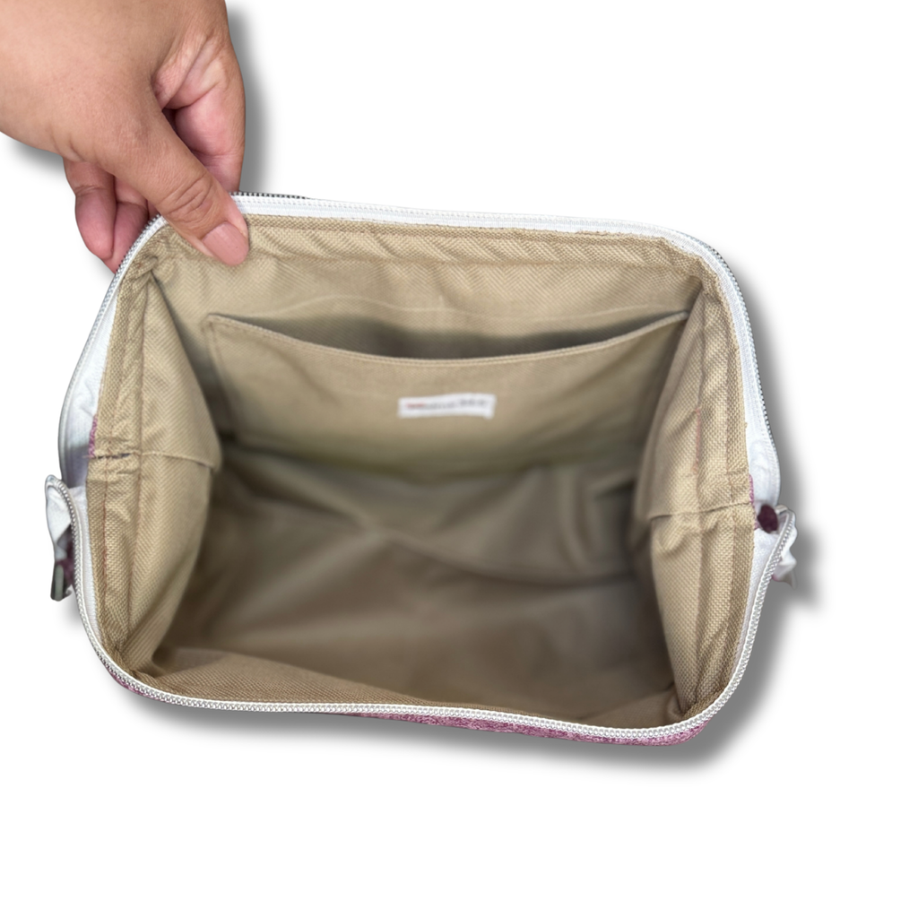 Hand opening a Solid Heathered Plum Full View Pouch to show the tan water-resistant interior lining and interior pocket