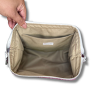 Hand opening a Solid Heathered Plum Full View Pouch to show the tan water-resistant interior lining and interior pocket