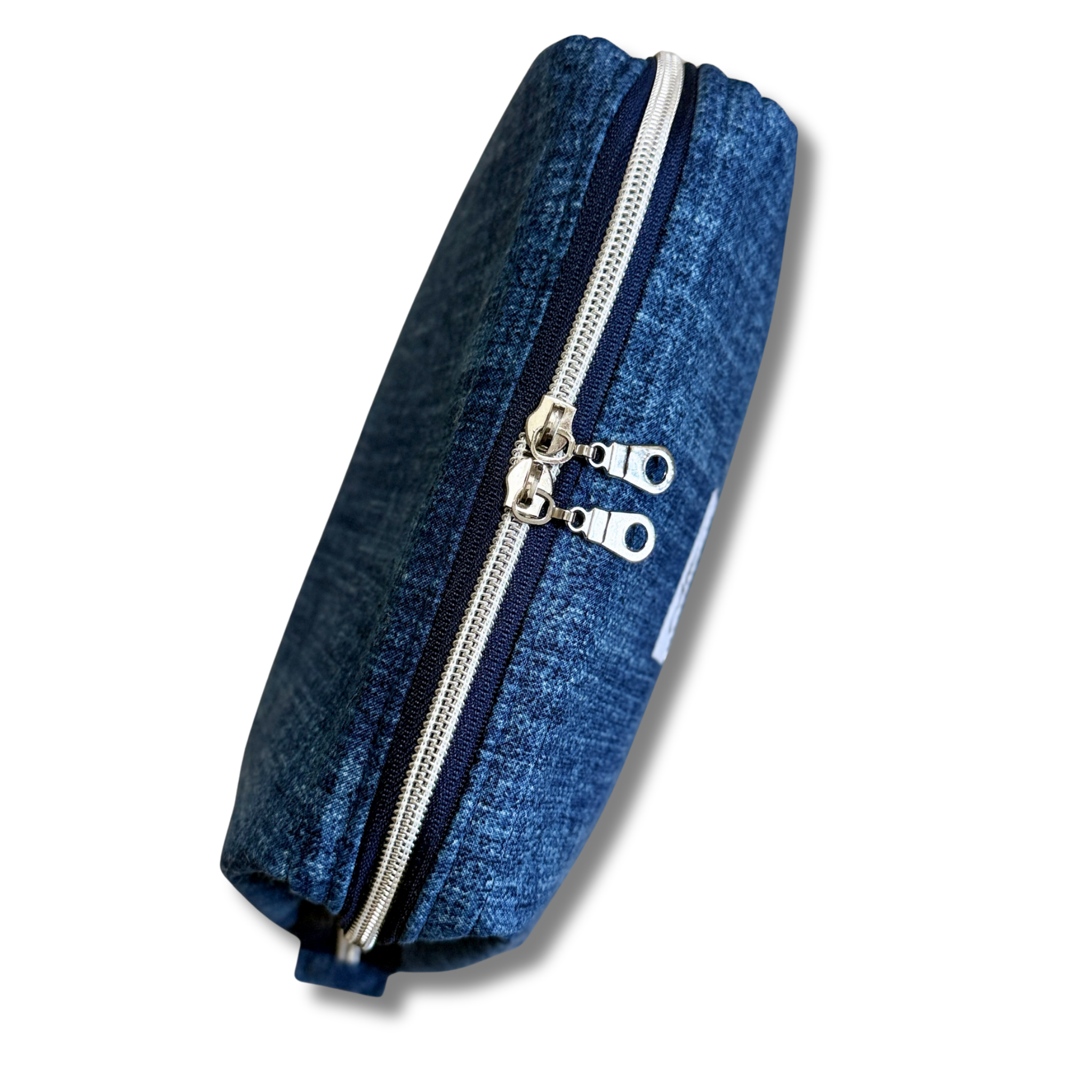 A blue denim pouch with dual silver metal zippers and silver zipper pulls, shown on a plain white background.