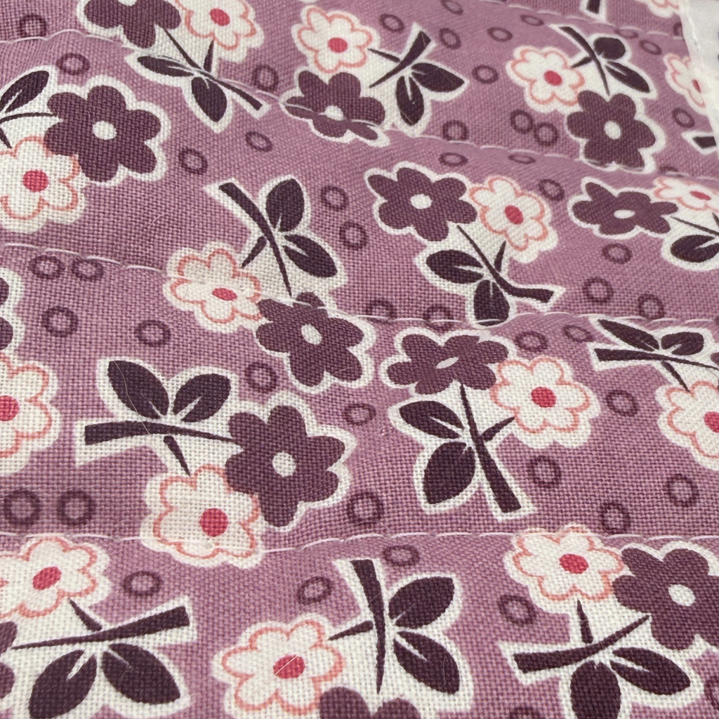 Close-up of the Purple Wildflower Bunch fabric print showing the dark floral pattern and quilted stitching detail